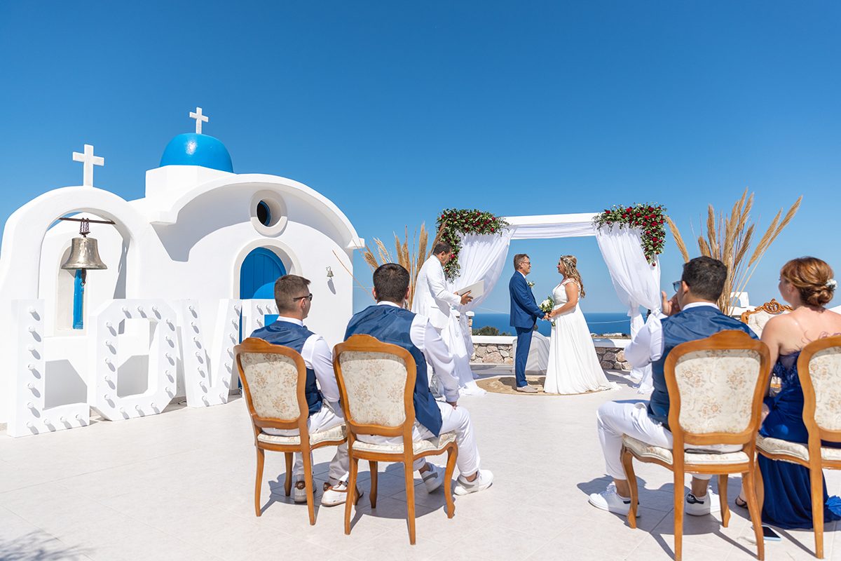 Ceremony in the courtyard of the blue-domed Saint Nicholas chapel with guests seated
