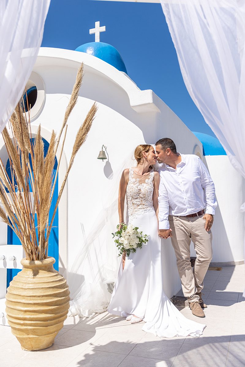 Couple beneath the ceremony gazebo at the blue-domed Saint Nicholas chapel