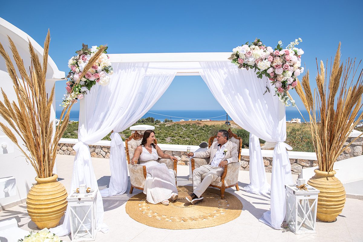 Wedding gazebo dressed with pampas grass on a Santorini terrace above the Aegean