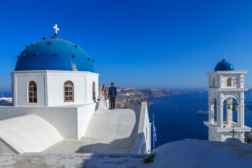 Blue-domed church and bell tower against the Aegean