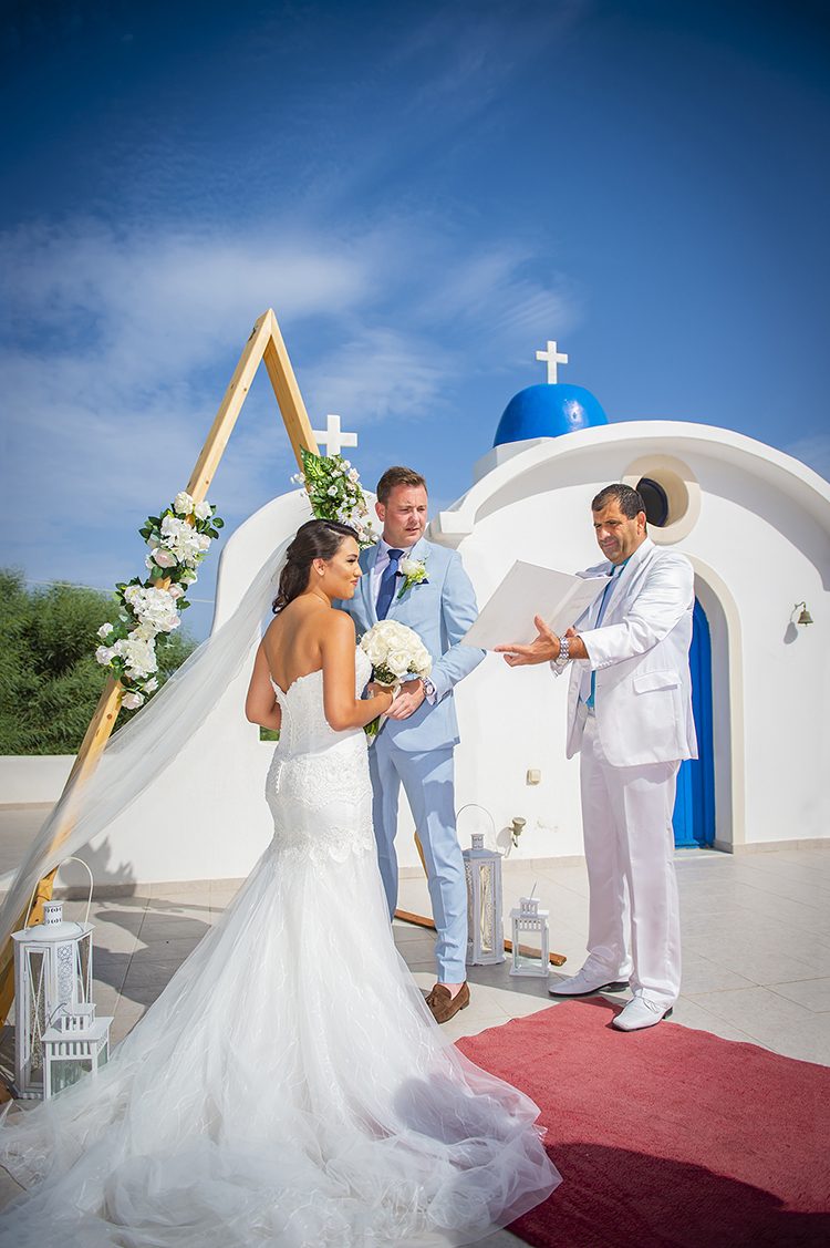 Couple beneath a triangular ceremony arch on the cliff edge