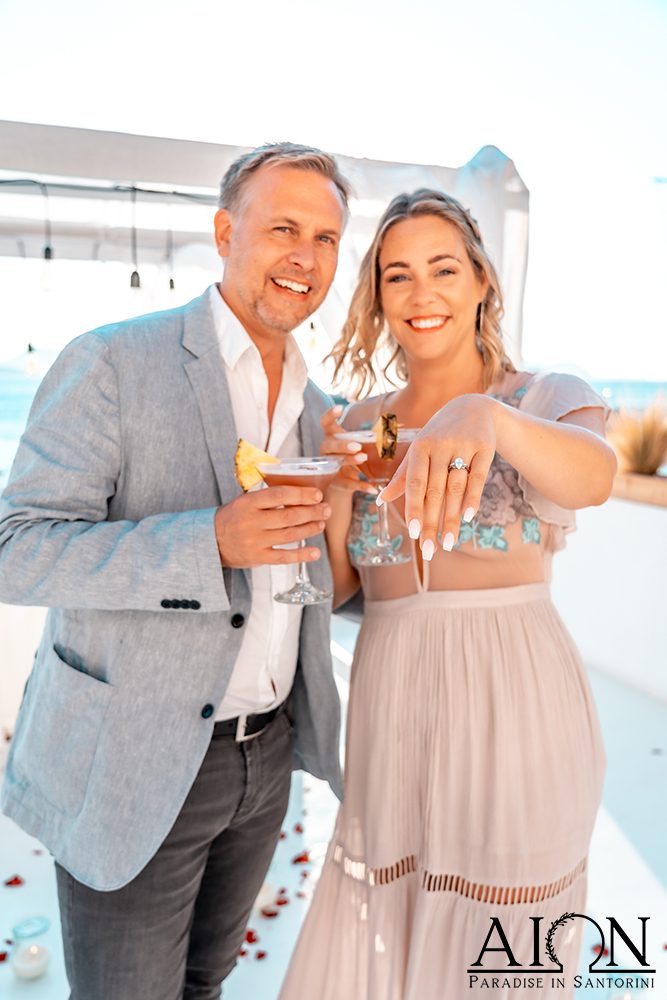 Newly engaged couple with champagne at Aion Santorini