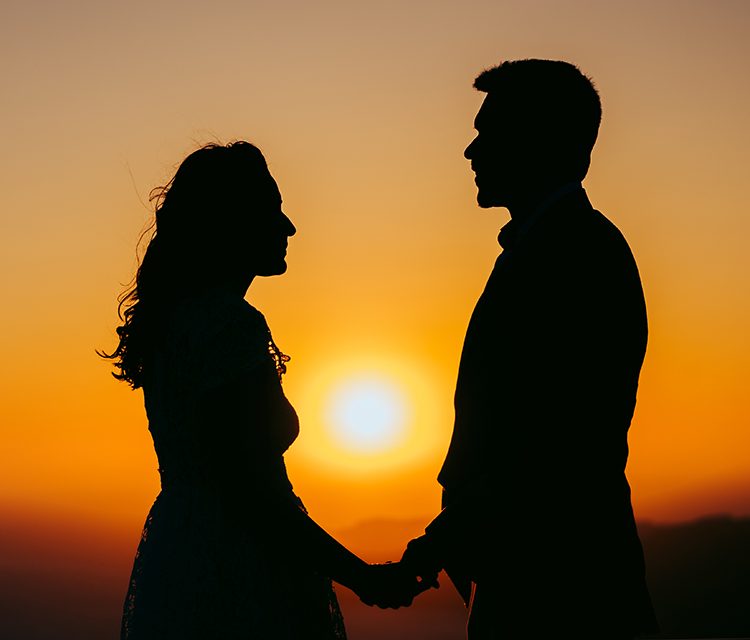 Couple silhouetted against the Santorini sunset