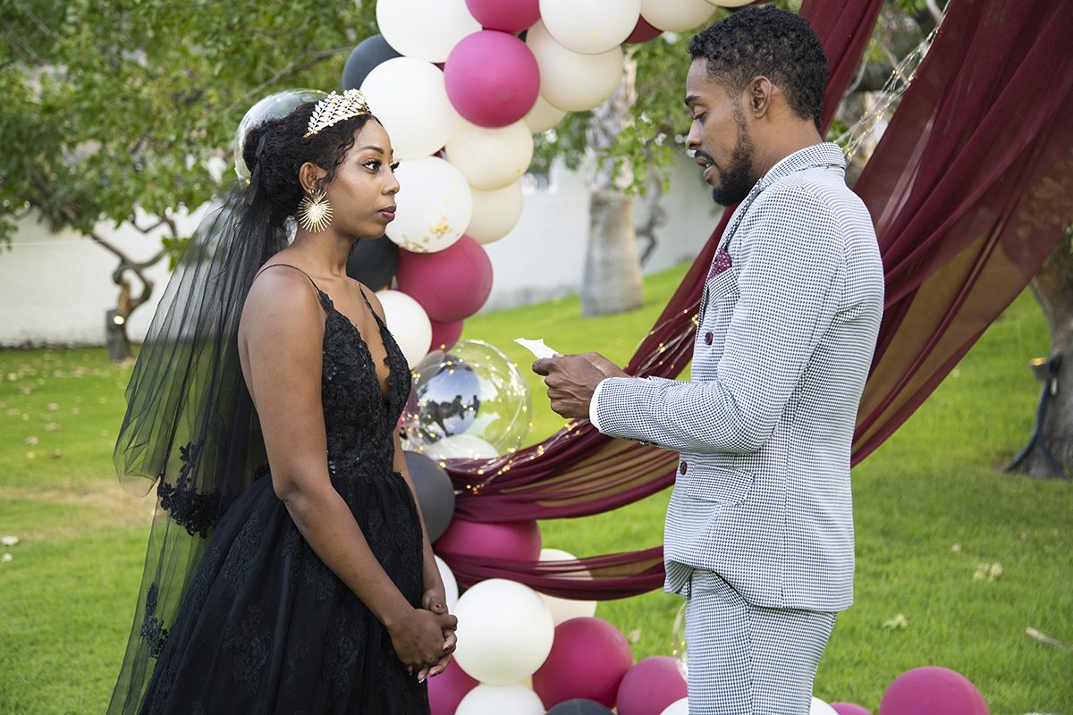 Couple exchanging vows beneath the ceremony arch