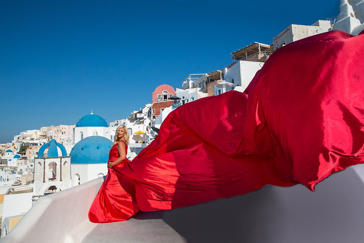 Red flying dress photographed at a blue-domed church