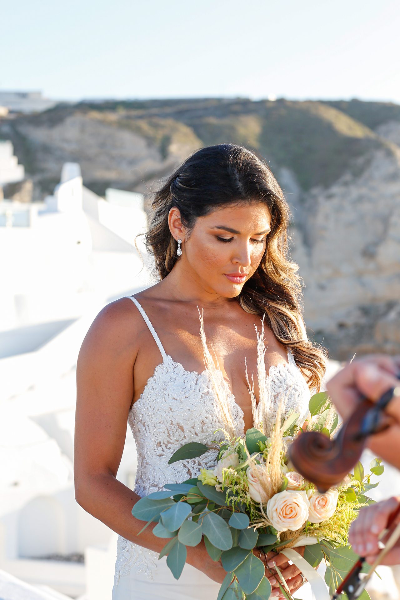 Bride holding a seasonal bouquet on the caldera path