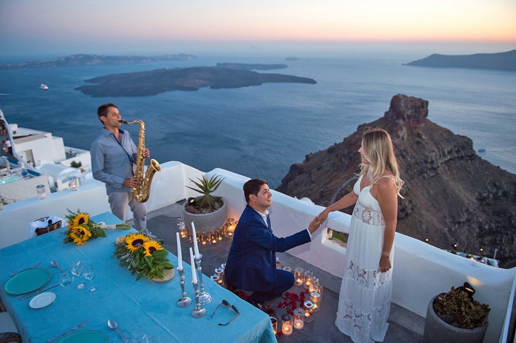 Couple with champagne on the cliff after the proposal