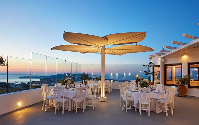 Reception tables set for a large Santorini wedding at Pyrgos restaurant