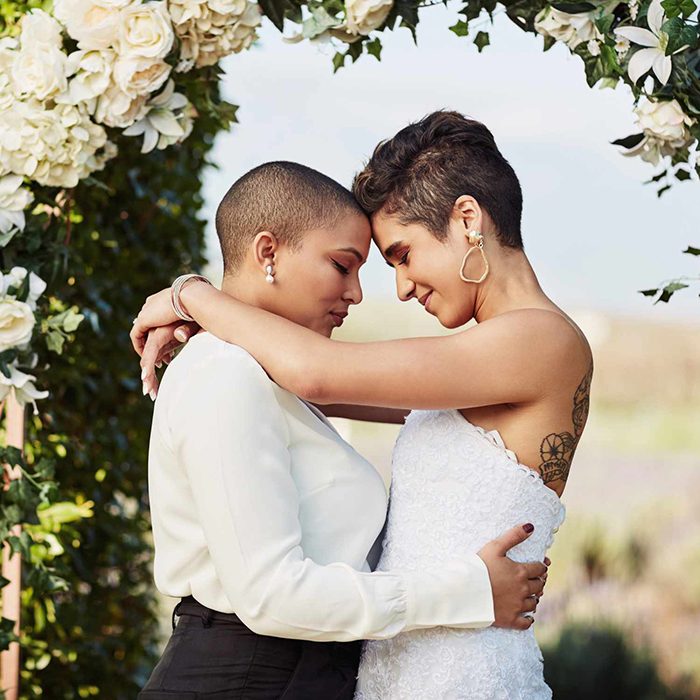 Two brides embracing after their Santorini ceremony