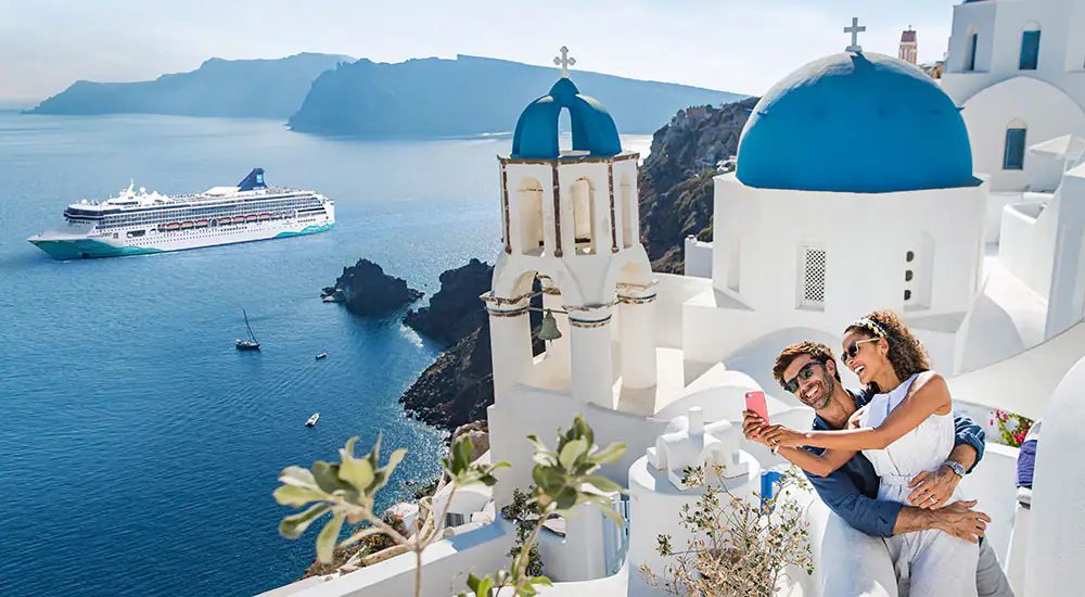 Sailing past the blue domes on the caldera
