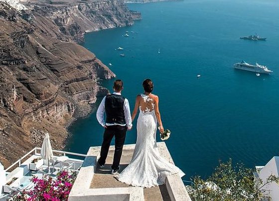 Couple photographed at sunset on the Santorini caldera edge