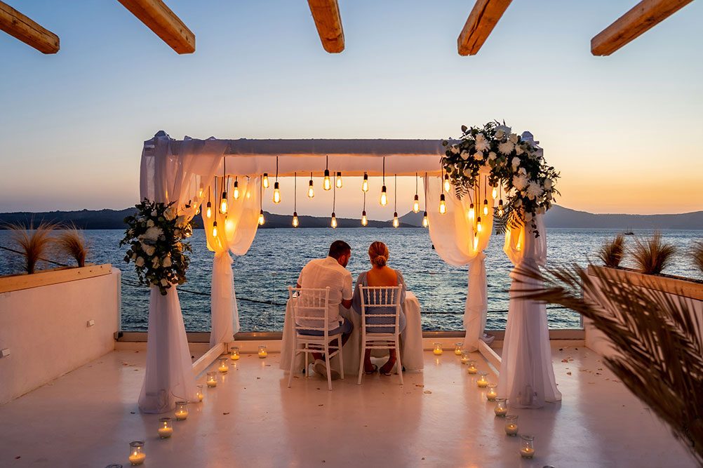 Santorini wedding venue terrace set for dinner above the caldera
