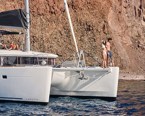 Catamaran anchored below the Santorini cliffs